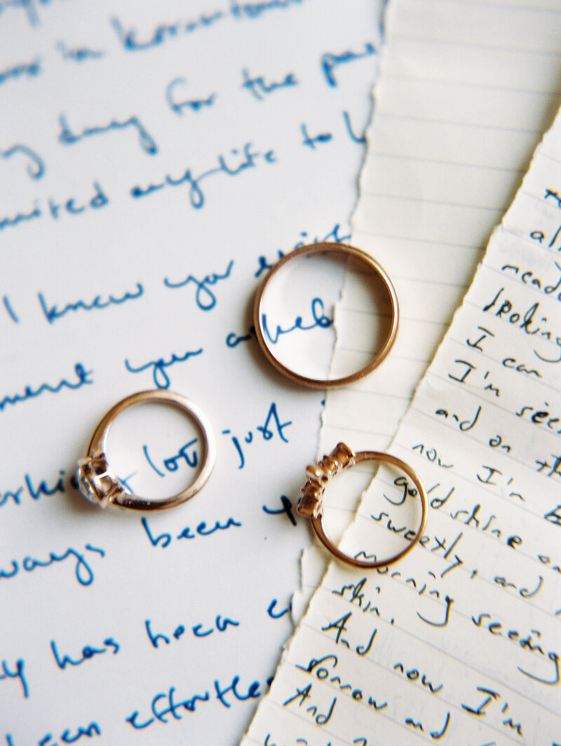A detail of the wedding rings on top of the bride and groom's vows, captured by the destination photographer My Sun and Stars Co.