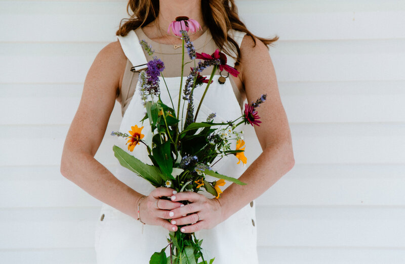 Sam holding a bouquet of wildflowers