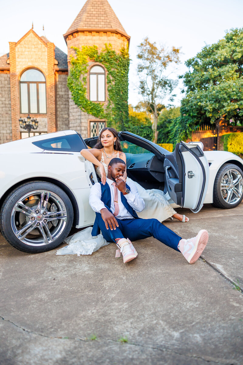 Wedding portrait of couple in front of car