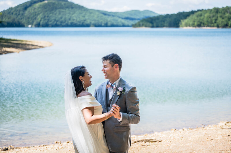 A couple on their elopement day in Roanoke, Virginia have their first dance along the shores of Carvin's Cove.