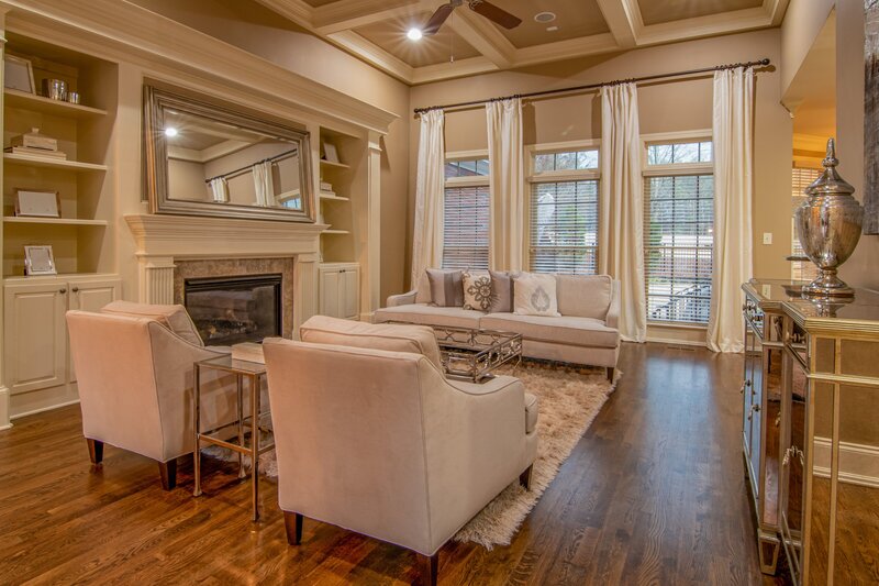 View of cozy living room with fireplace and coffered ceiling
