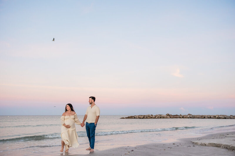couple gets maternity photos taken at sunrise on St. Pete Beach