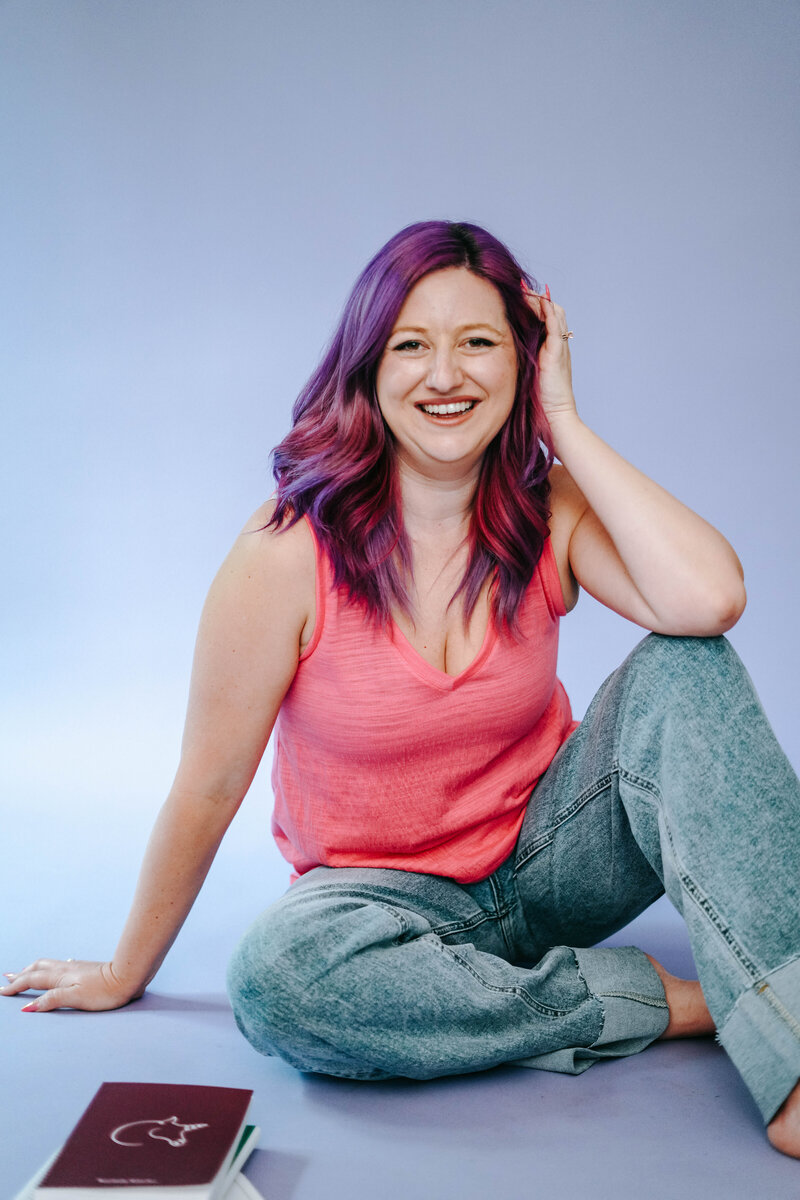 Photography Business Coach | Karinda K | Karinda sitting at a purple studio