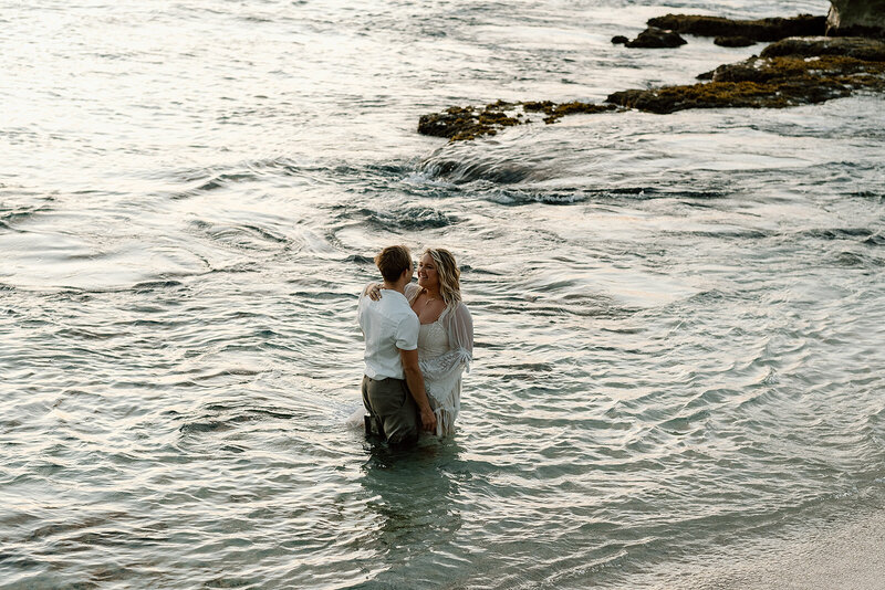 bride and groom in the ocean of Hawaii