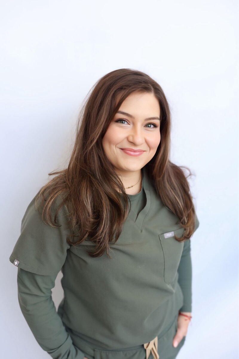 Smiling woman sitting by the poolside, wearing a stylish pullover sweater. Enjoying leisure time outdoors with a relaxed and content expression. Perfect blend of comfort and style for poolside relaxation.