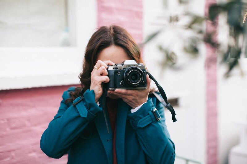 A photographer looks through a camera to shoot a photo