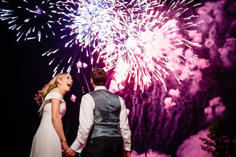 A summer wedding celebration in Hudson New York beneath fireworks.