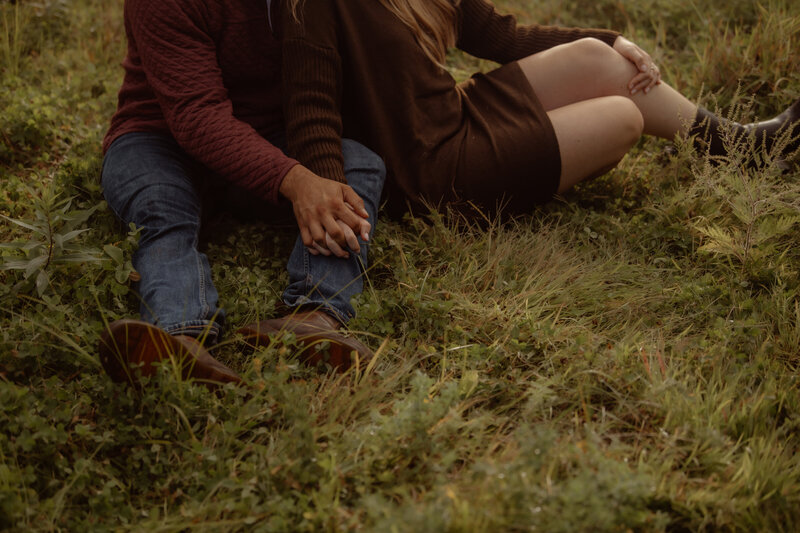 Emotive storytelling photo of a couple hiking through a rural field for their engagement session