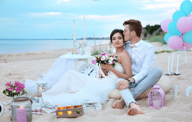 Bride and groom photo session by the beach, groom kissing the forehead of her wife