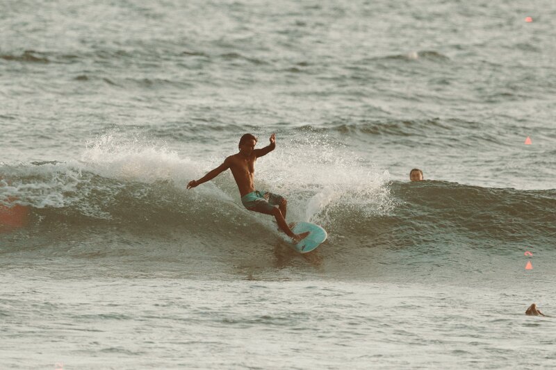 Jey surfing on the beach in Canggu, bali.