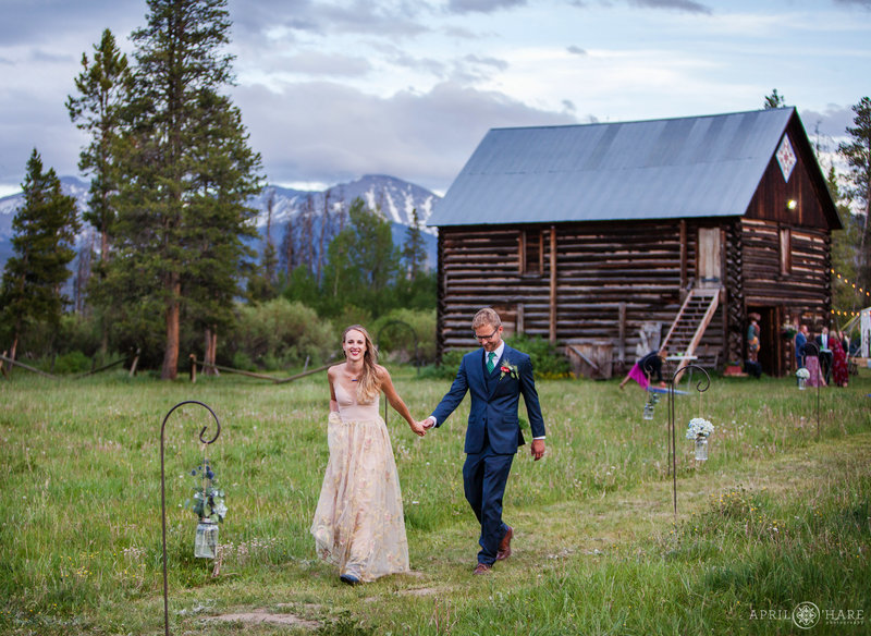 Couple walks down grassy aisle hand in hand at B Lazy 2 Ranch in Fraser