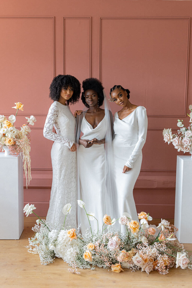 three women in bridal gowns with floral decor