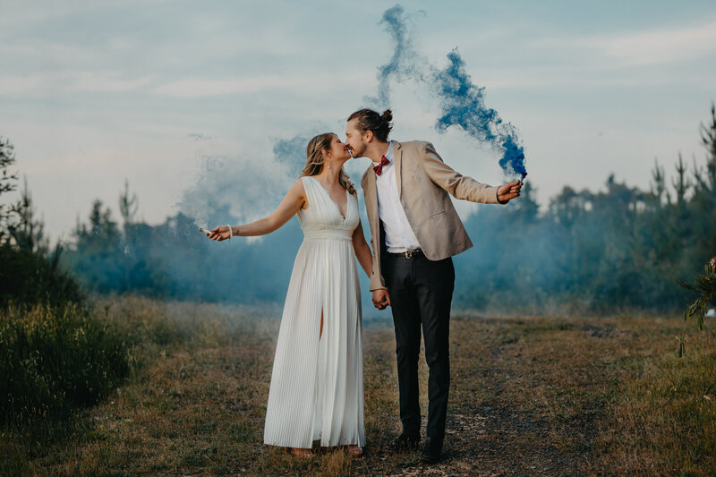 blue smoke bomb portrait  with bride and groom kissing