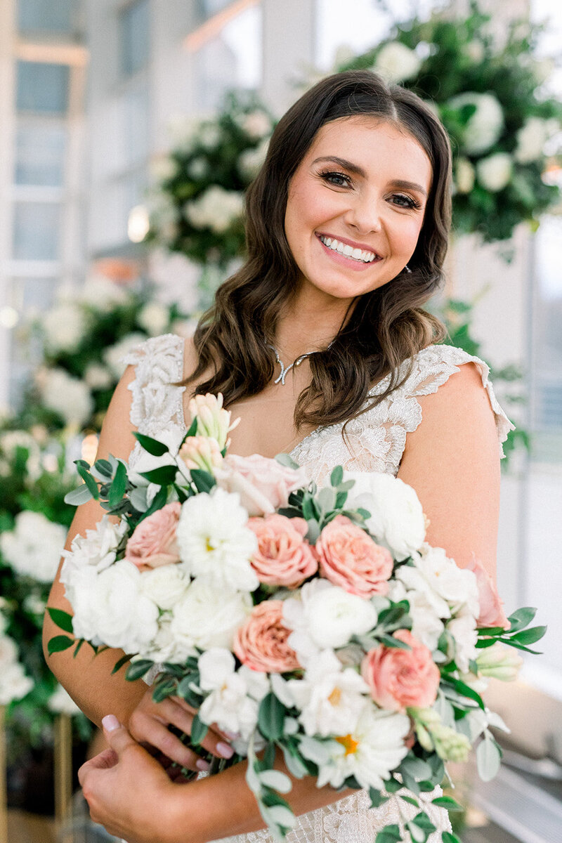 bride smiling holding pink and white flowers