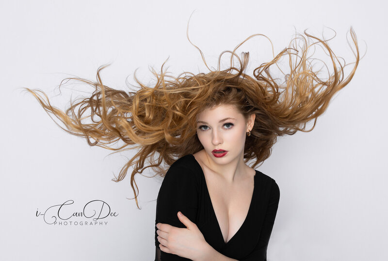 Experience the beauty of dramatic fashion photography with I-CanDee Photography. This captivating portrait features a model with long, flowing red hair, enhanced by a fan to create a dynamic, ethereal effect. Captured with artistry and precision, this image showcases the elegance and movement of the model’s hair in a way that makes it one of my favorite shots. Based in Charlotte, NC, I-CanDee Photography specializes in creating stunning, high-impact images that highlight the unique beauty of each subject.