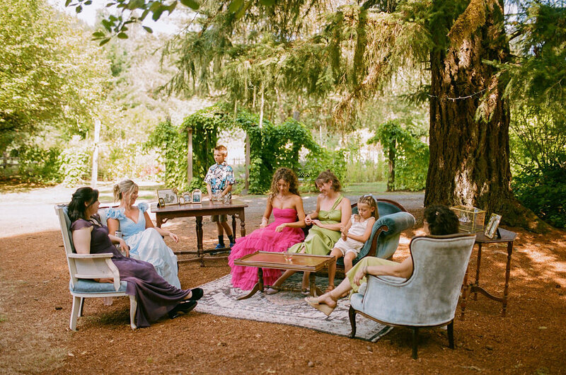 Guests sitting in a wedding lounge area, with rental seating from Birdie June Events and Rentals