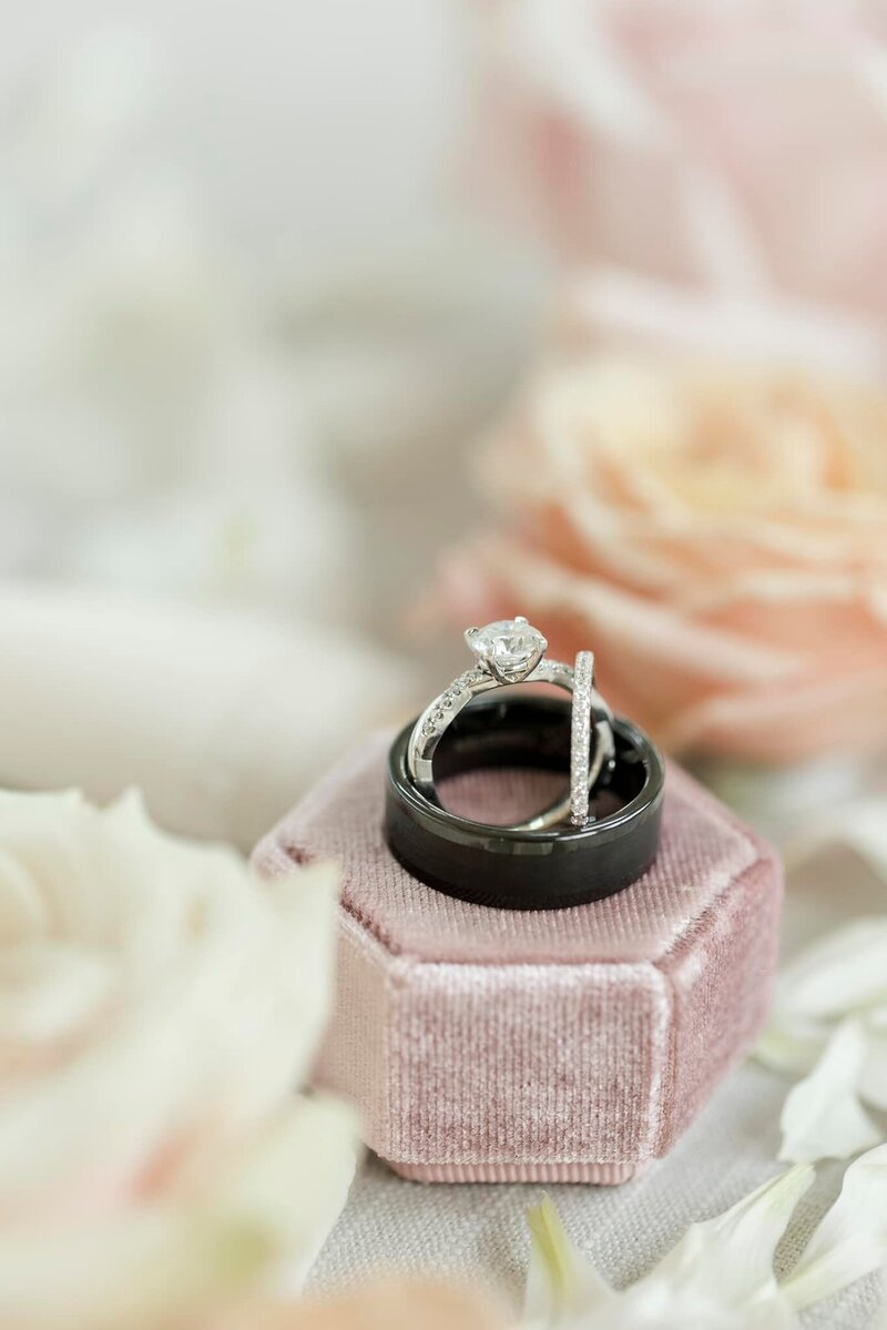 Close-up of the couple’s wedding rings nestled in a small floral arrangement at August House wedding venue.