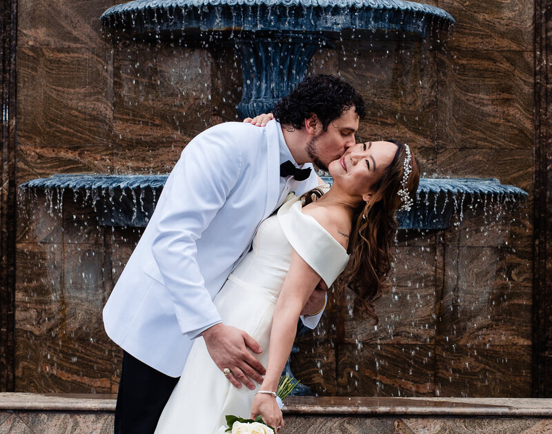 Asian bride being kissed and dipped in front of sparking fountain at Marina del Ray's venue.