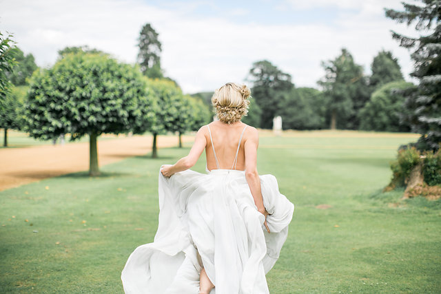 bride running in garden in flowing wedding dress