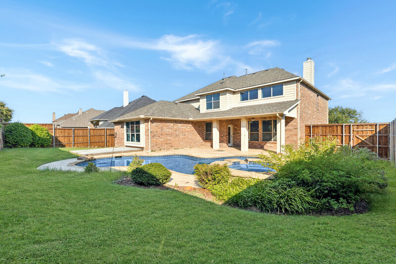 Modern open-concept kitchen and living space with floor-to-ceiling windows showcasing downtown Dallas views. Natural light fills the entire room, highlighting the clean, minimalist aesthetic.