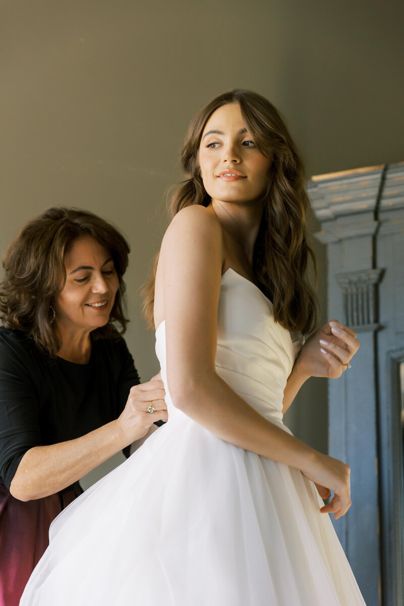 Jamie's mom helping her put on her wedding dress