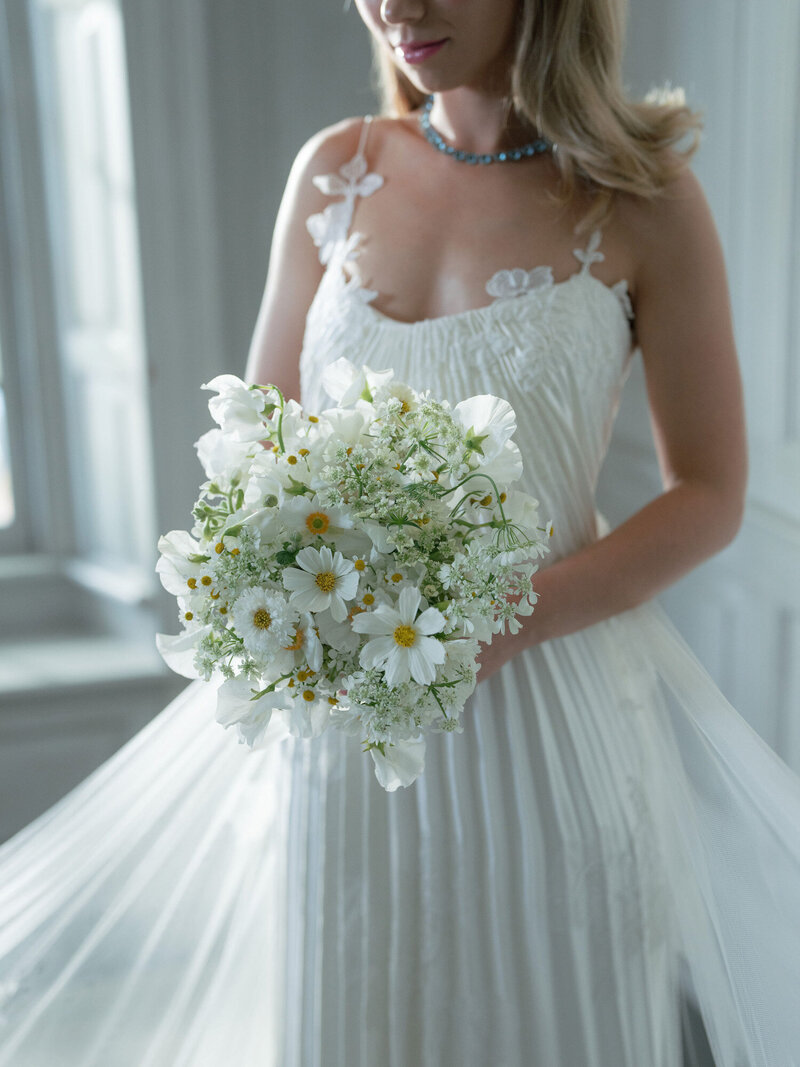 Portrait of bride holding her white and green bridal bouquet