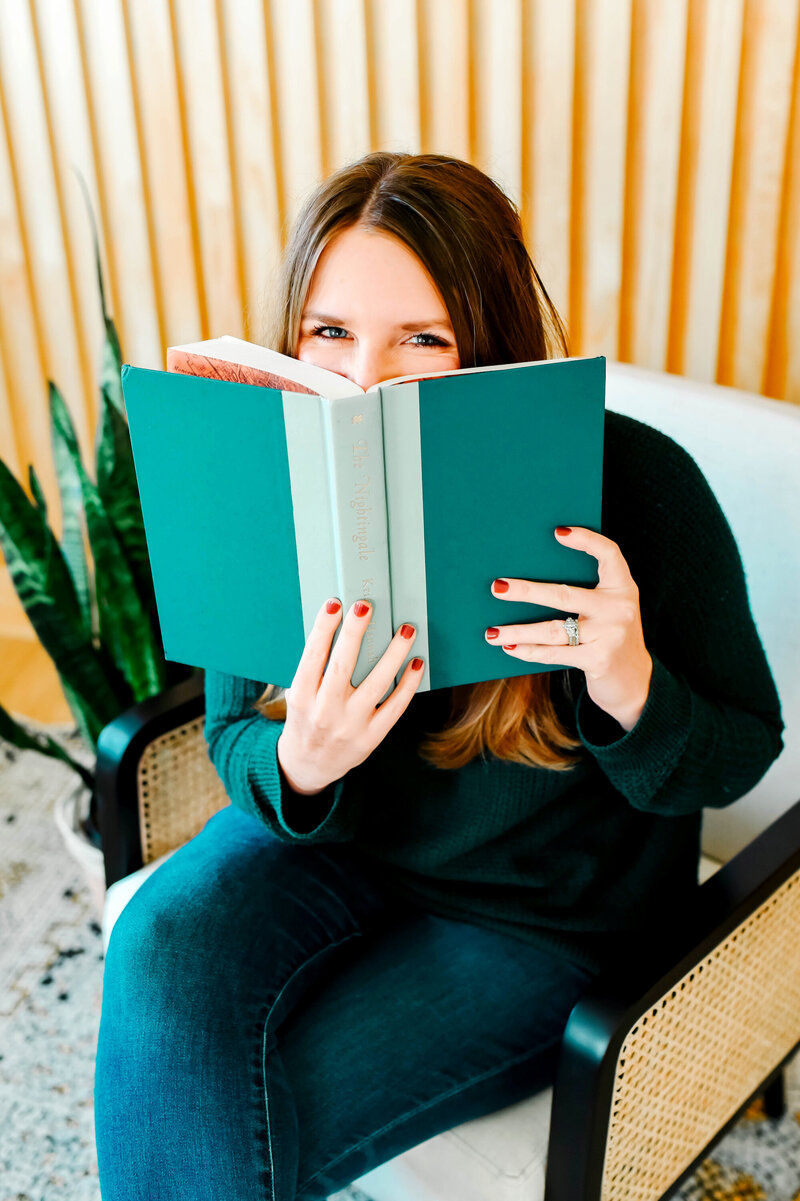 Writer smiling behind green book