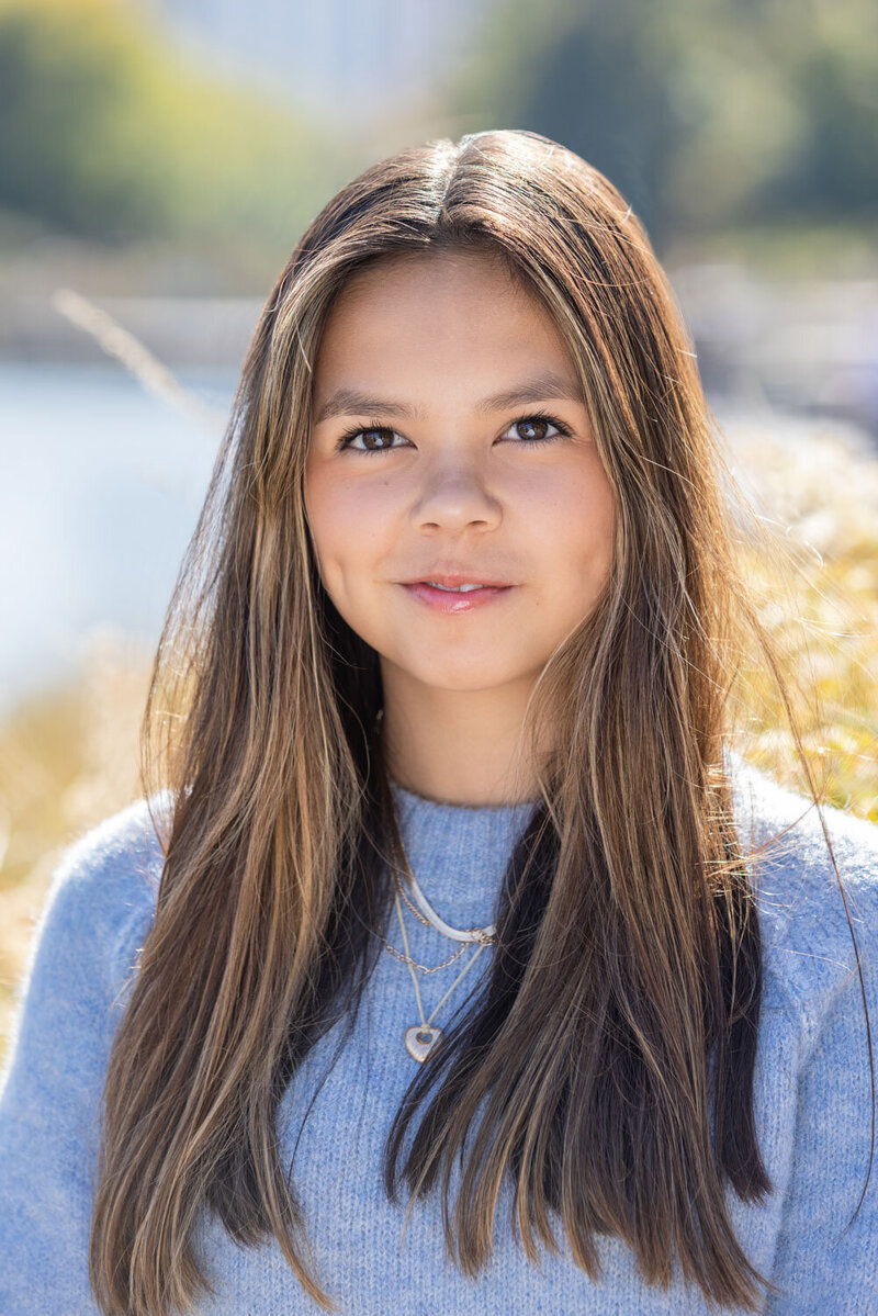 Girl in a light blue sweater in an outdoor setting