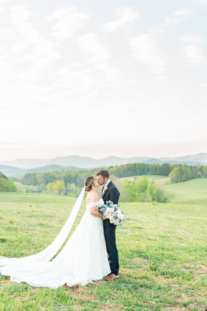 Bride and groom kissing with bouquet