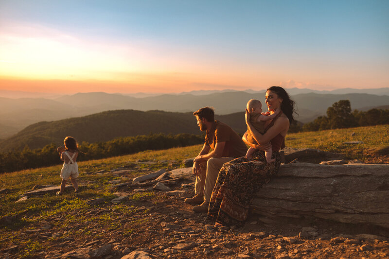 Family Photography, family of four sitting on mountaintop during sunset
