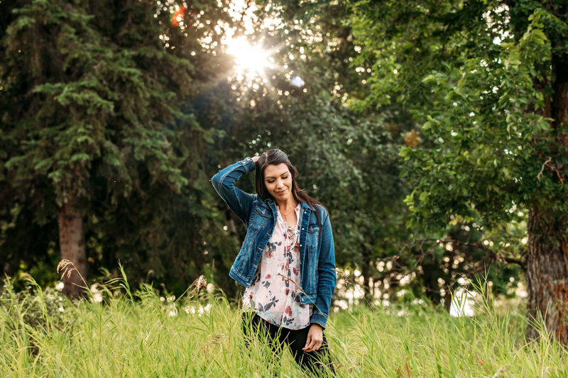 indigenous model in jean jacket  standing in tall grass