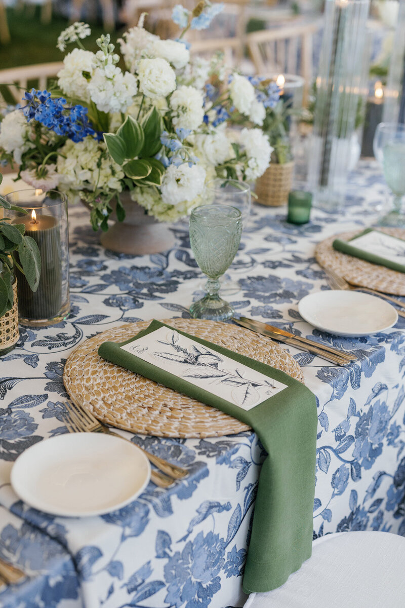 Close up of a tented wedding with pops of blue, white and green