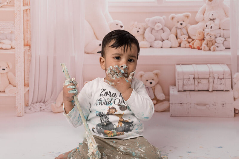 One year old boy eating cake