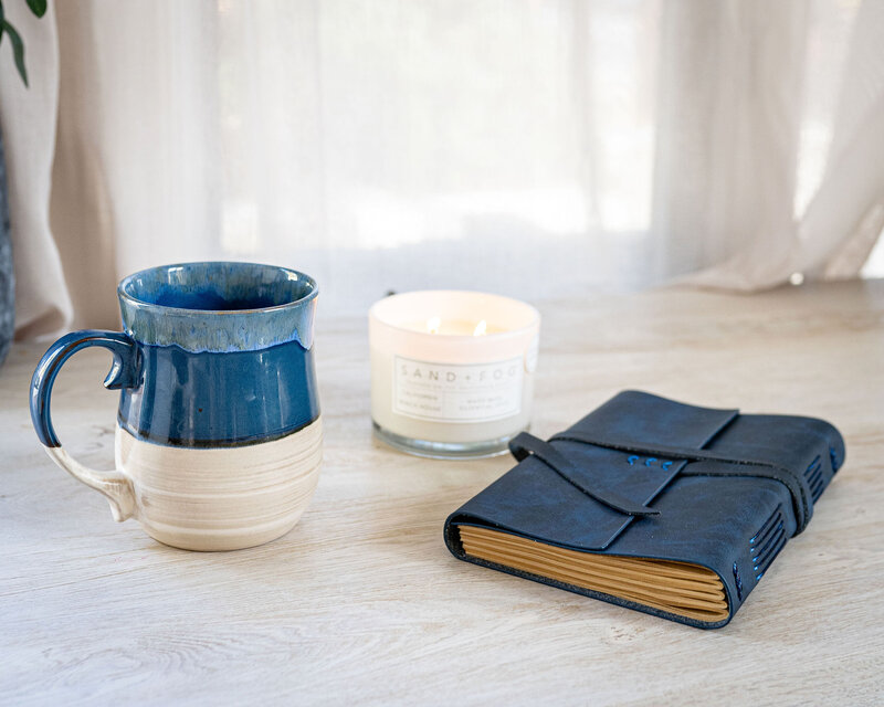 Mug Candle and Journal on Table