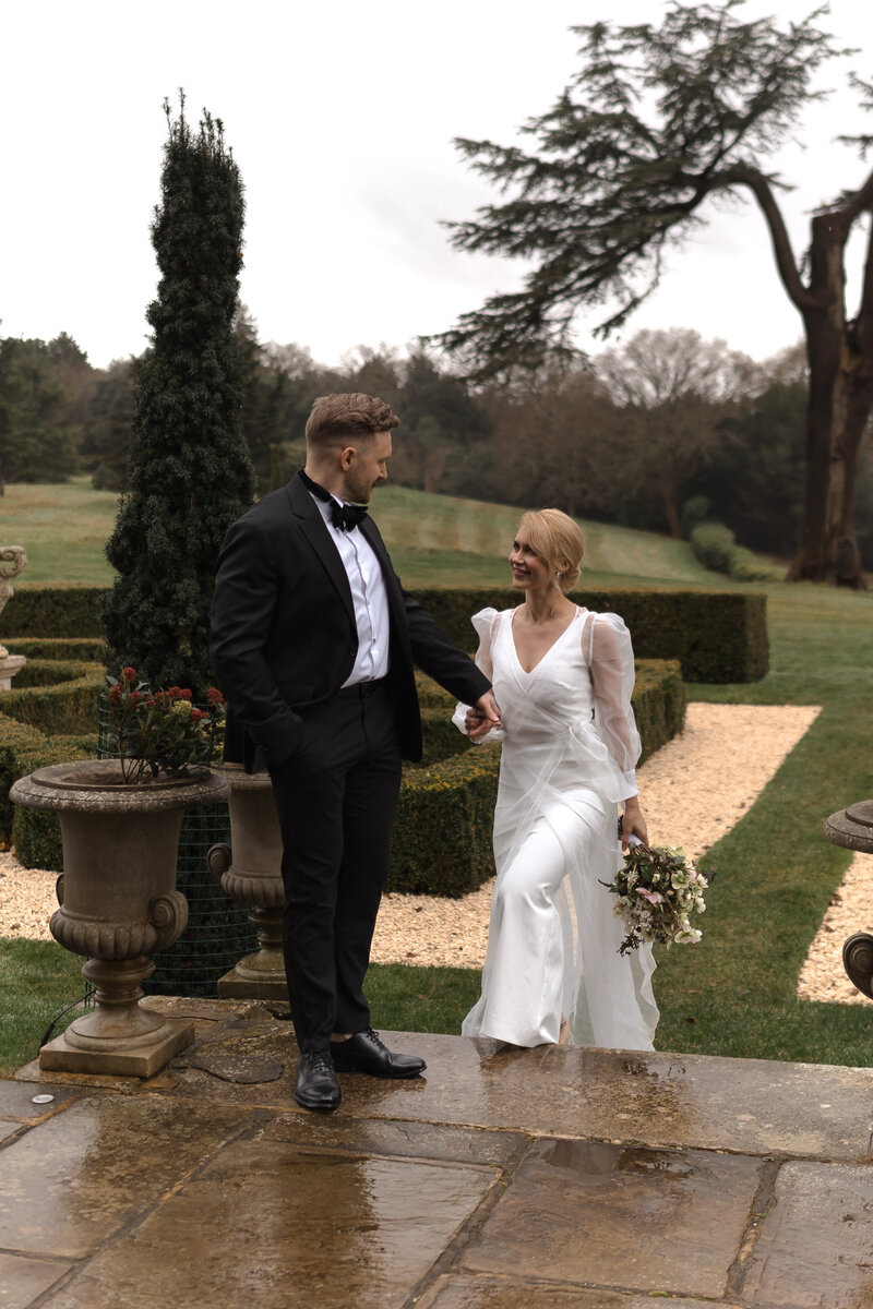 Wedding photographer captures couple taking a stroll hand in hand at their french chateau wedding.