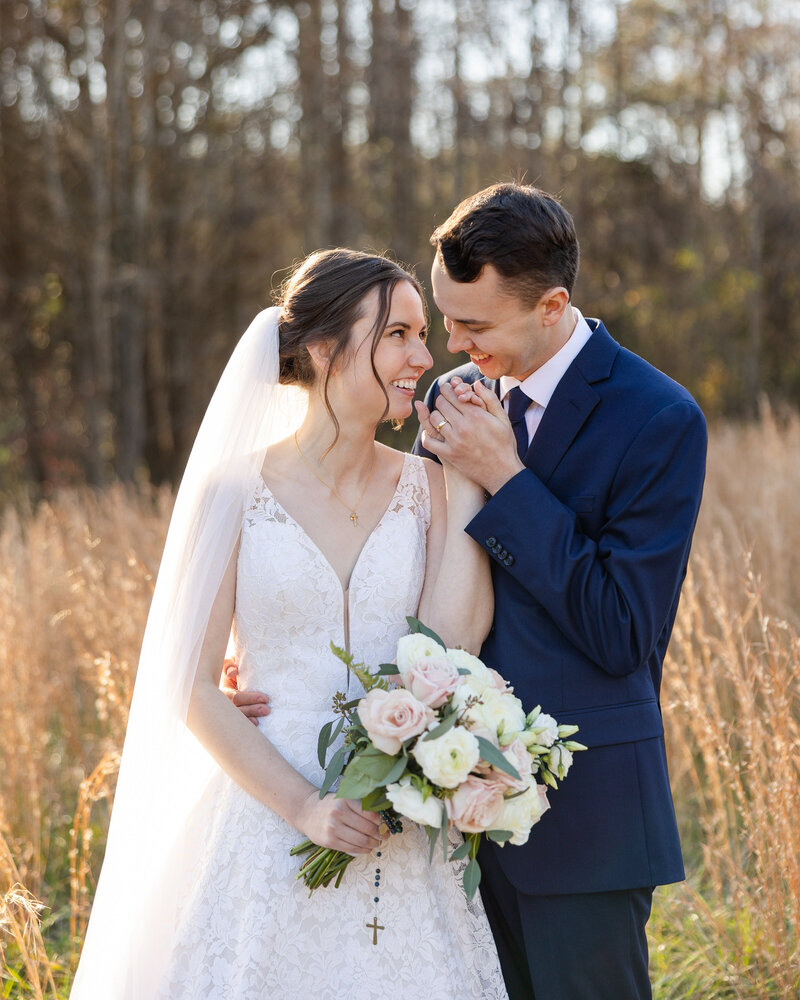 a bride and groom smiling in a field