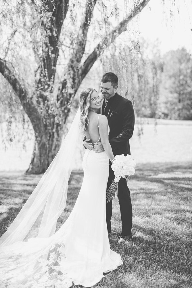 Bride and groom embracing with a bouquet of flowers