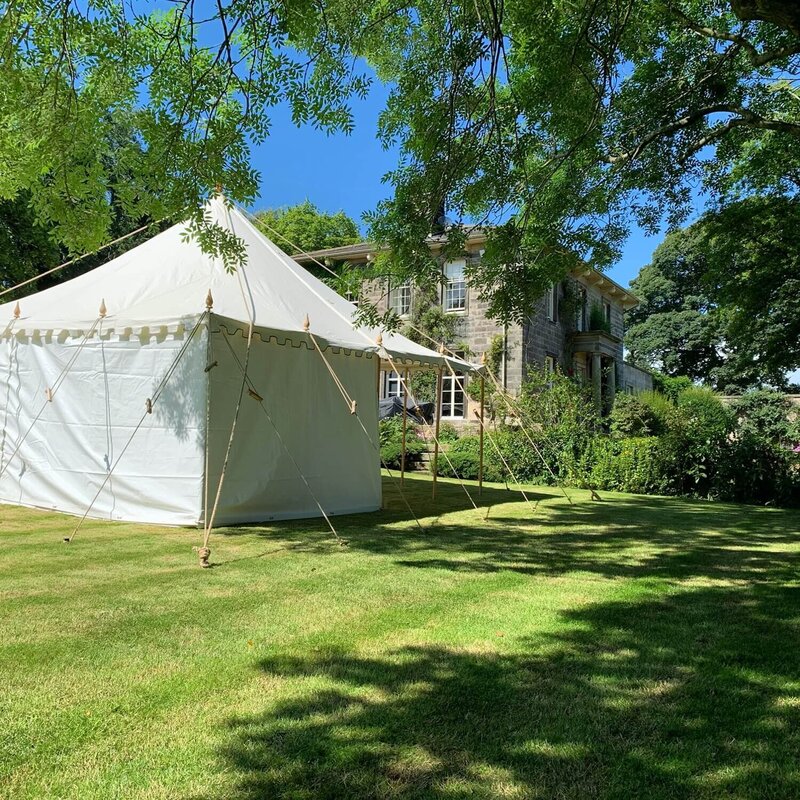 A small pole marquee with lots of ropes tying it down to the ground