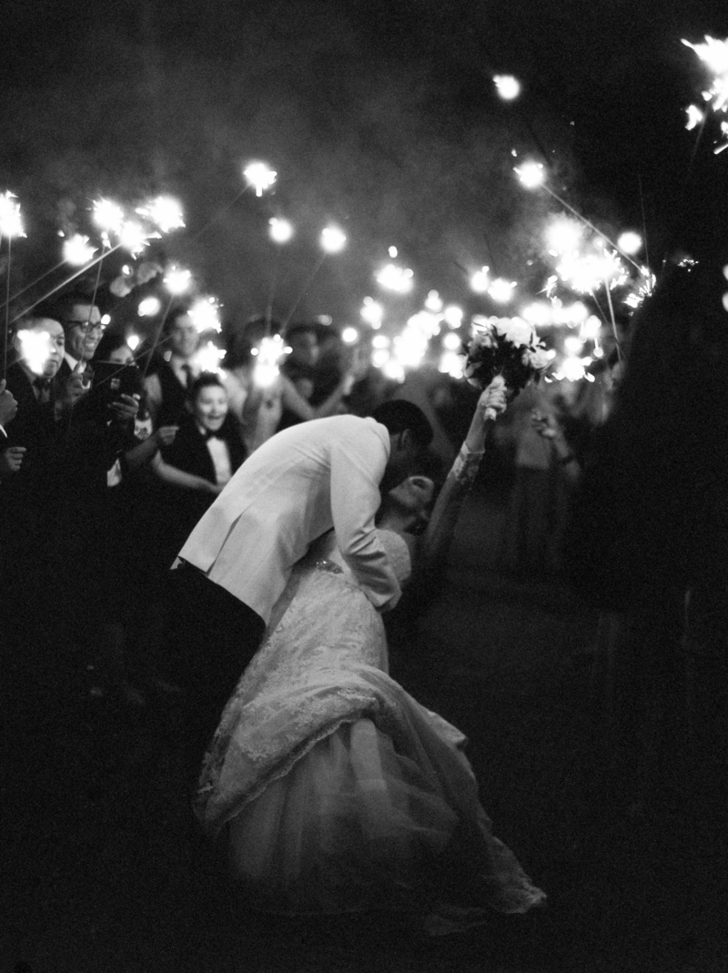 Indie and artistic film elopement wedding photograph of a bride throwing her boquet in thei air for the last kiss with their  closest friends and family in Santa Barbara