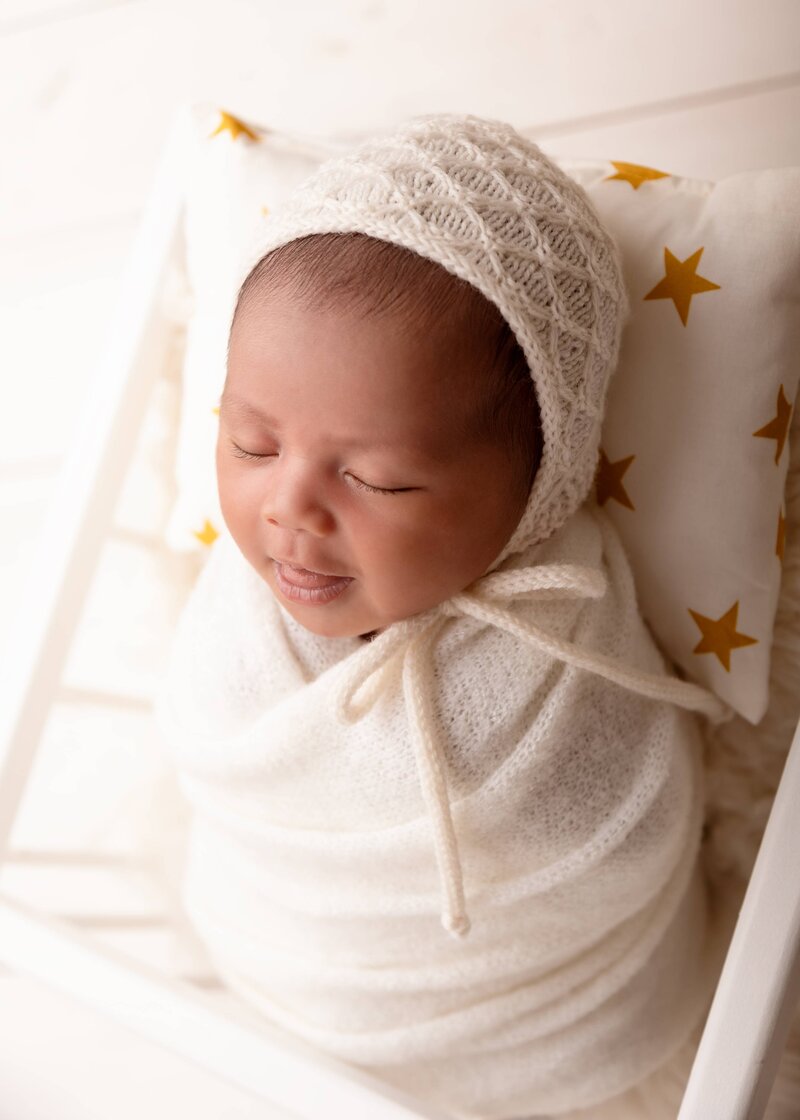 A softly wrapped newborn nestled in a cozy crib, Edmonton studio