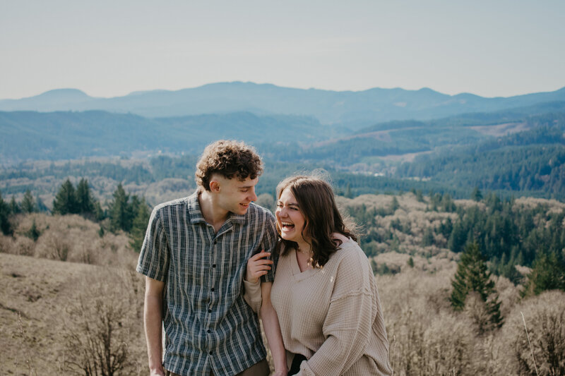 Couple laughing and holding hands while hiking in Corvallis.