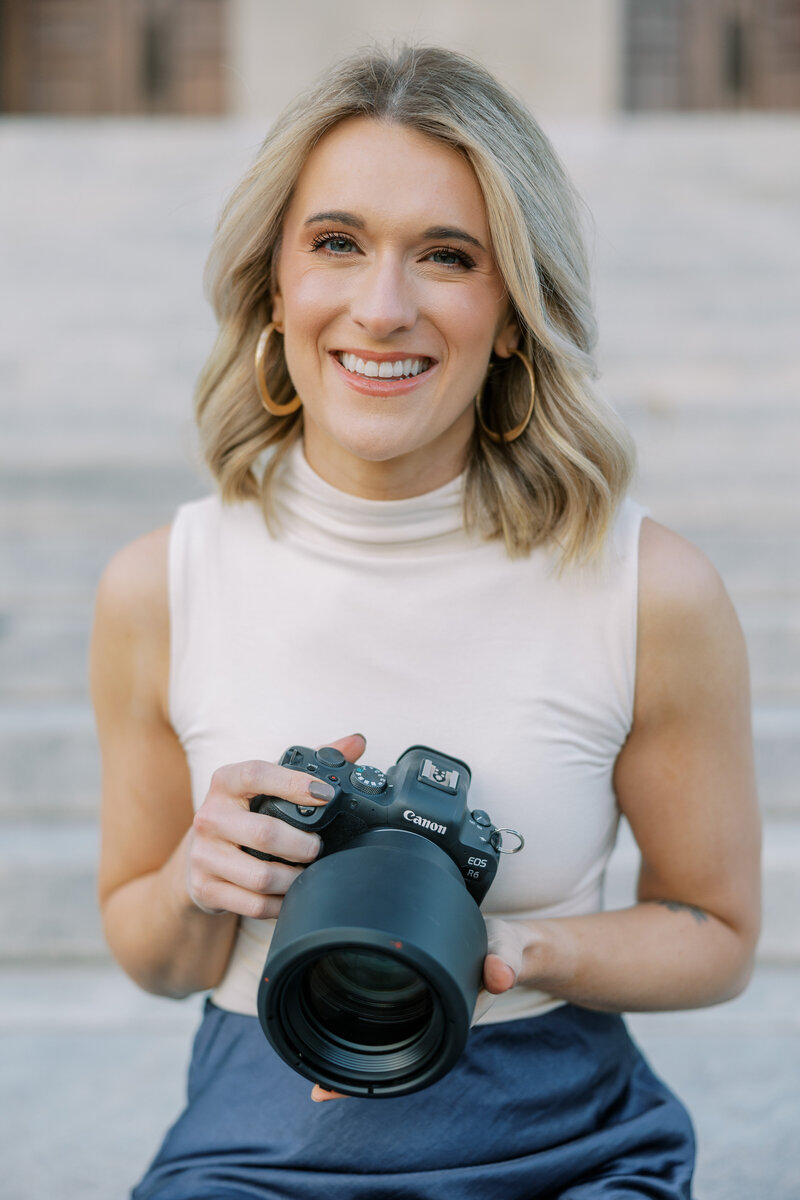 Photographer Shelby Mullins smiles at the camera, wearing a green and white stripped t-shirt