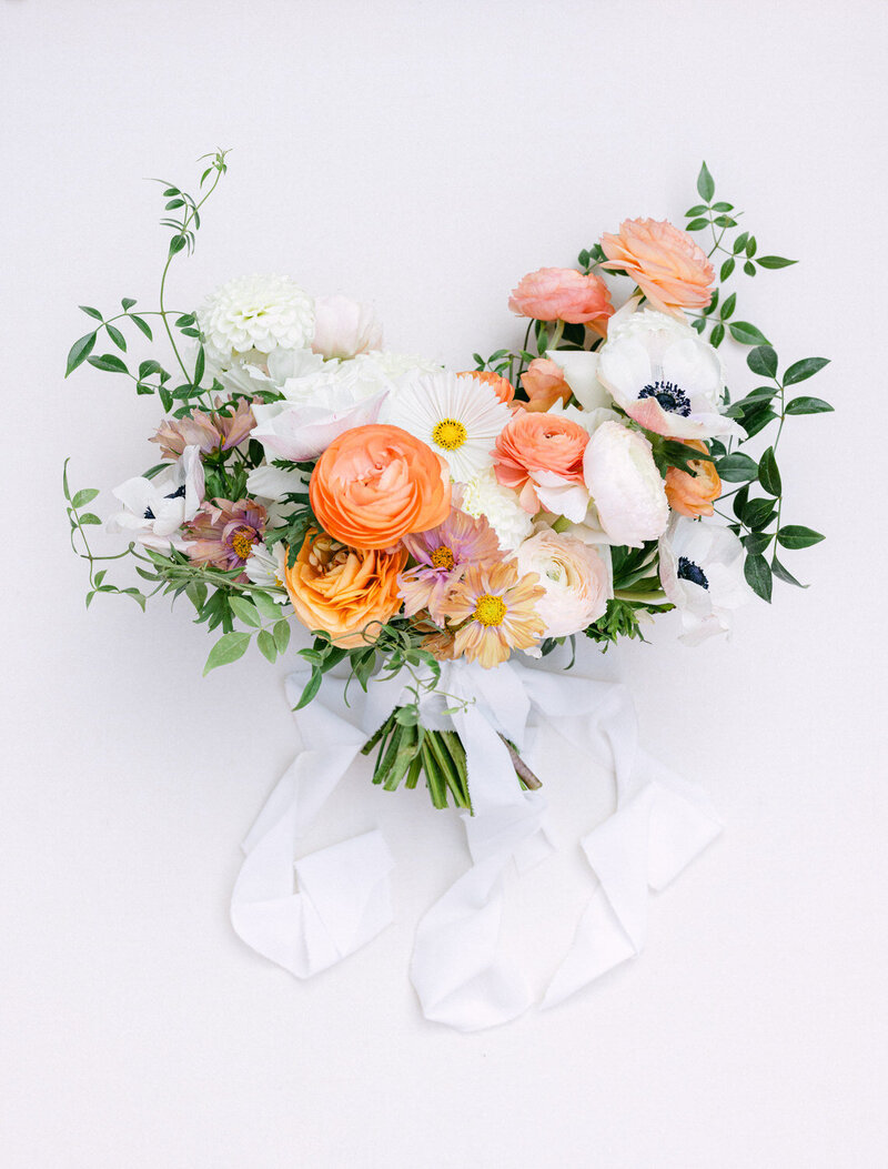 This elegant layflat photograph showcases the bride's bouquet beautifully arranged on her wedding day. The intricate details of the flowers and the thoughtful composition reflect the sophistication and style of her special celebration.