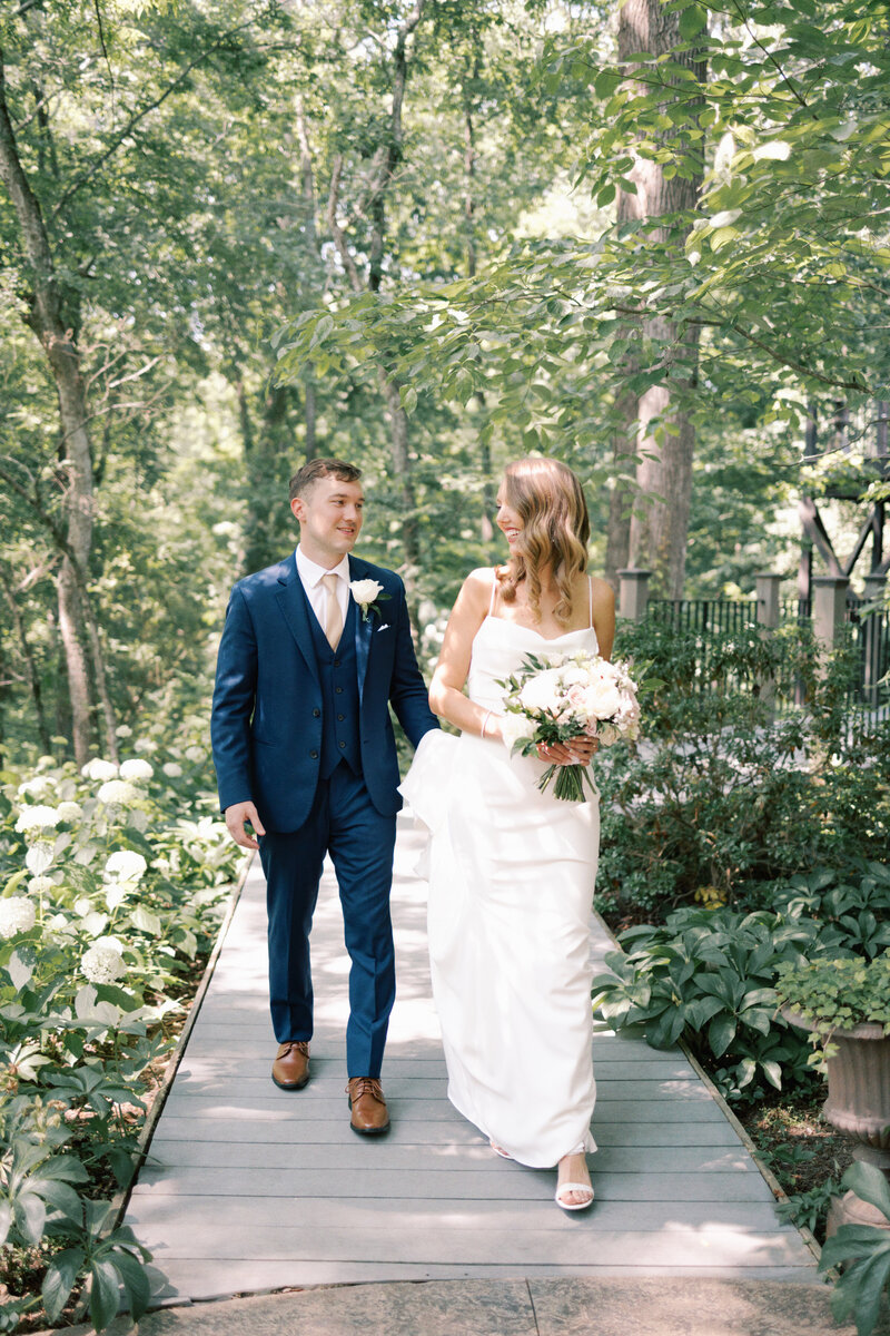 Bride and groom kiss next to rose bush.