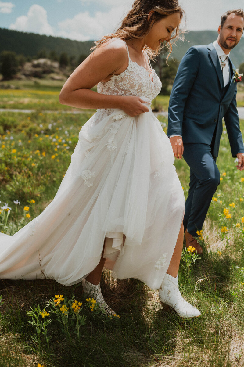 bride and groom walking through the fields on their wedding day in Rocky Mountain National Park