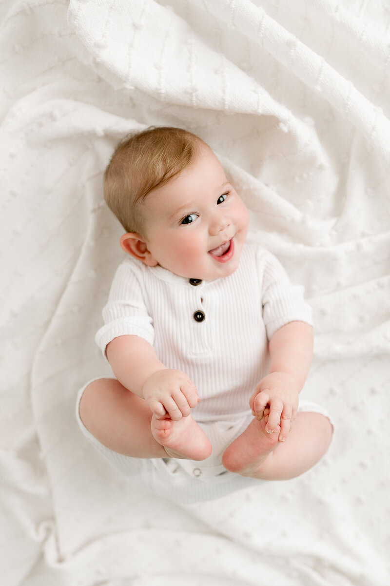 Baby holding feet in studio natural light Swanton, Ohio