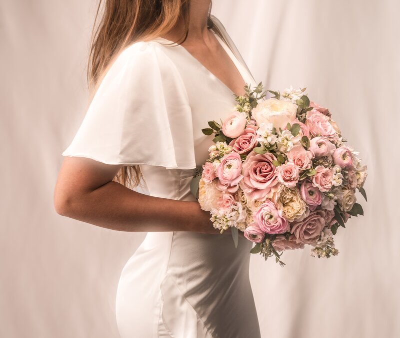 bride holding pink and white fresh wedding bouquet