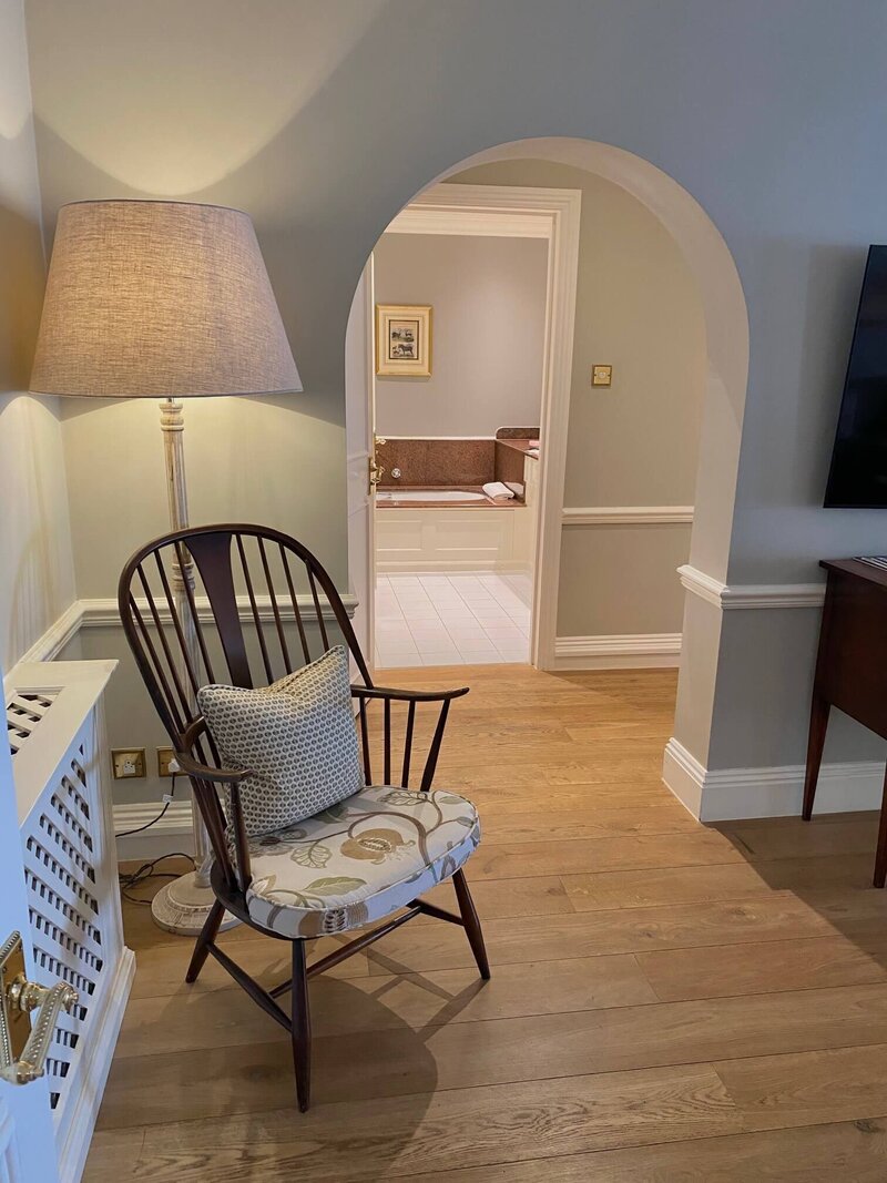 room with wooden chair and arch walkway 