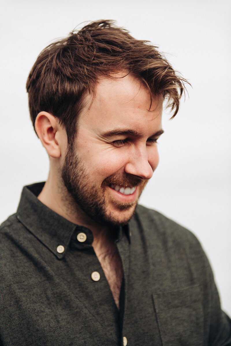 Portrait of Tom Keenan smiling with a fashionable background