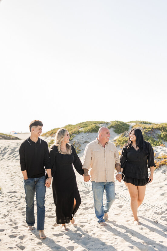 family with grown children walking in sand dunes Coronado Beach